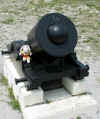 Sparky sitting on mortar cannon with cannon ball stuck in it